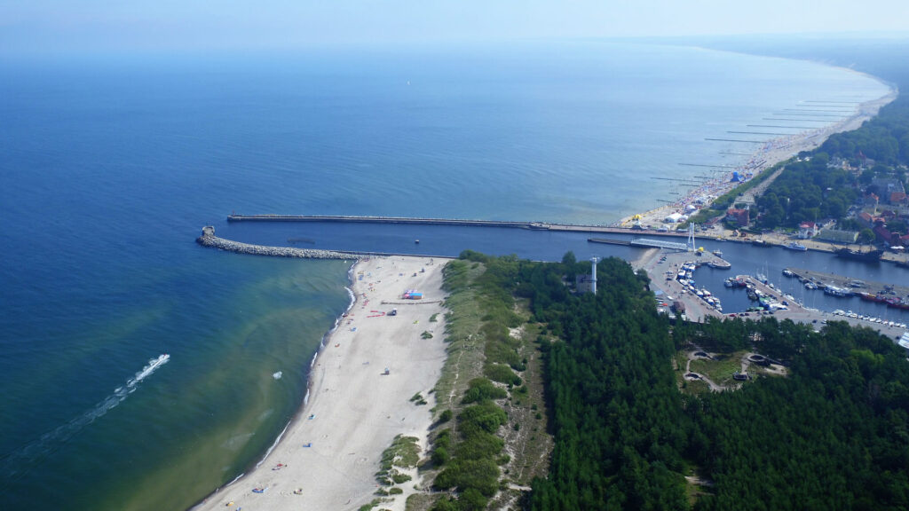 Zu sehen ist ein Blick über den Hafen und den Strand von Stolpmünde, Bild: Jarek-Piech